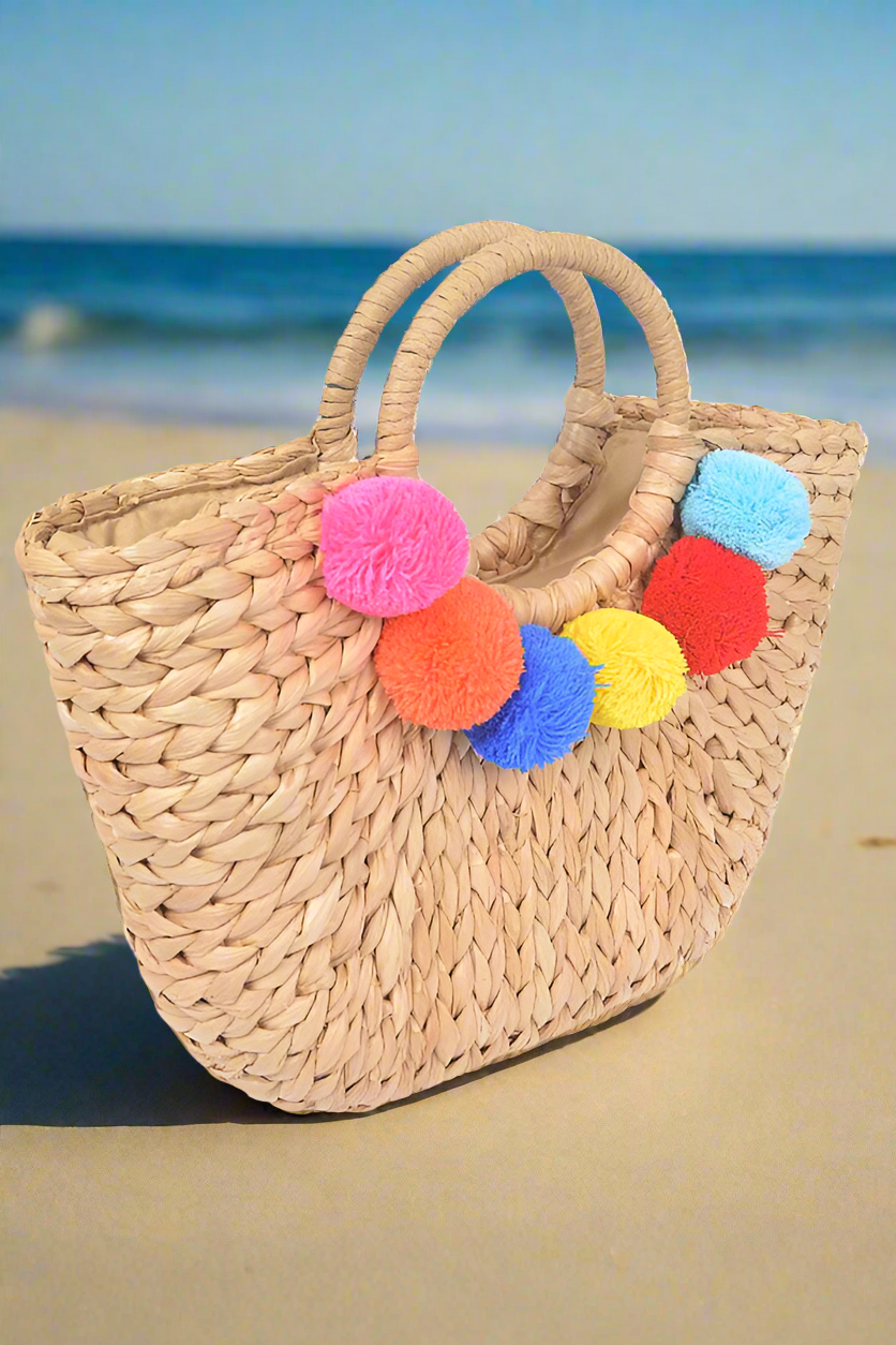 "Tote bag" con pompones. Construcción en paja para un estilo mas tropical.